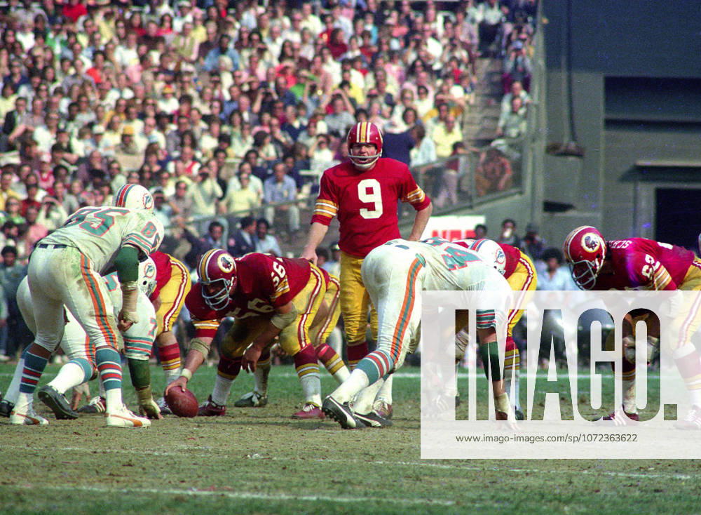 Washington Redskins quarterback Sonny Jurgensen 9 calls signals as he prepares to take the snap from center Len Hauss 56 during the game against the Miami Dolphins at RFK Stadium in Washington, DC on October 13, 1974. Also pictured are Dolphins middle linebacker Nick Buoniconti 85 Dolphins right defensive end Bill Stanfill 84, and Redskins left tackle Ray Schoenke 62. The Redskins won the game 20 - 17 Washington USA - ZUMAs152 19741013_faa_s152_004