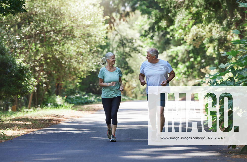 Senior couple, exercise and happy outdoor for a run, workout and training on road for fitness. Elderly man and woman talking about cardio for health and wellness while jogging or running in nature. (License=RF) 20065306 ,model released, Symbolfoto