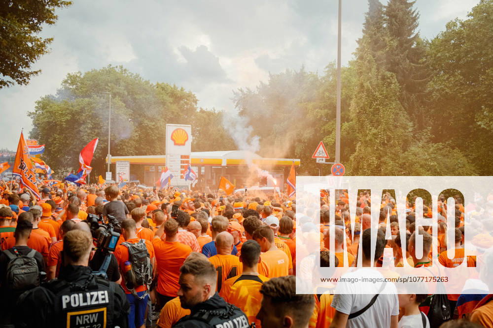 Football, UEFA EURO, EM, Europameisterschaft,Fussball 2024, Netherlands Fan March Police officers observe a large crowd of Netherlands supporters with flags and orange smoke near a petrol station in Dortmund, Germany, during the fan march before the UEFA Euro 2024 semi-final against England. Dortmund Dortmund NRW Germany