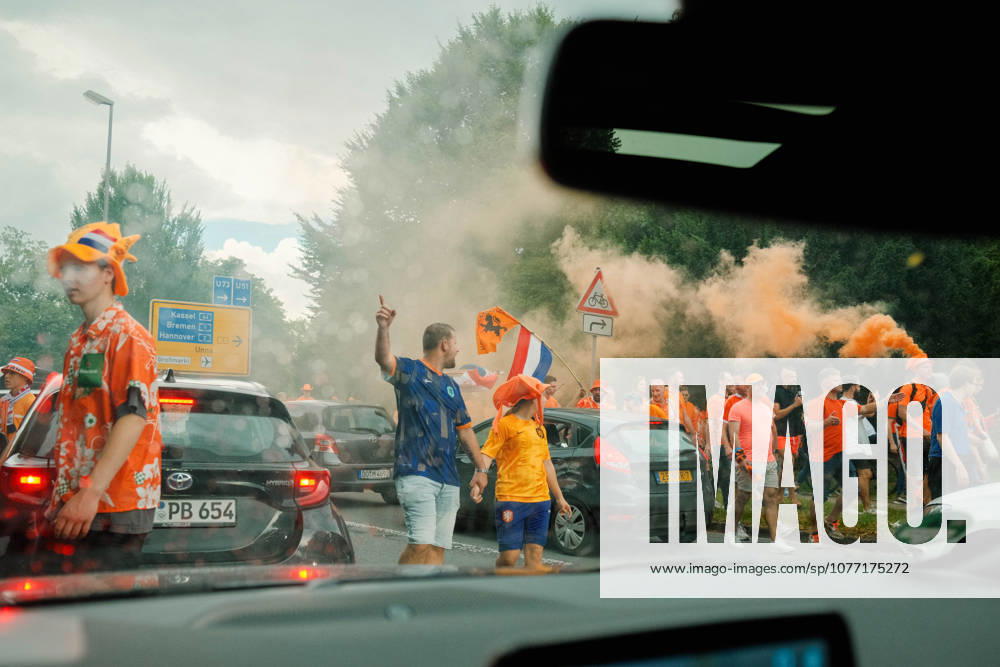 Football, UEFA EURO, EM, Europameisterschaft,Fussball 2024, Netherlands Fan March Netherlands fans and traffic mix on a road in Dortmund, Germany, as orange smoke rises during the Dutch fan march ahead of the UEFA Euro 2024 semi-final match against England. Dortmund Dortmund NRW Germany