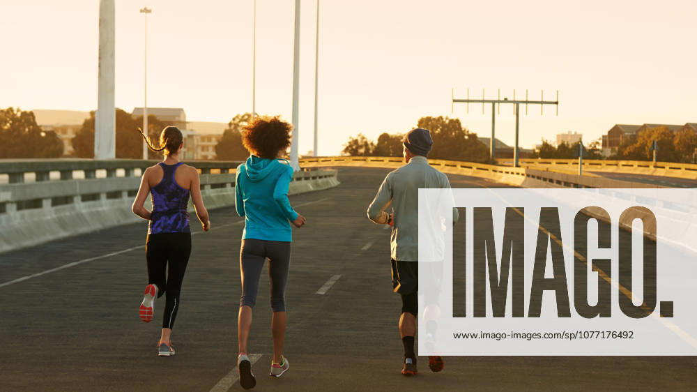 Not a care to bother us. Rearview shot of three young joggers running down an empty street at dawn (License=RF) 20242357 ,model released, Symbolfoto