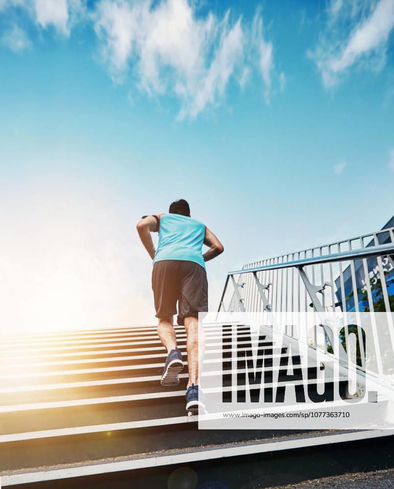 Back, fitness and running with man, stairs and exercise with progress, sunshine and challenge. Rear view, steps and runner in city, lens flare or training for wellness, healthy or energy with workout. (License=RF) 21848710 ,model released, Symbolfoto