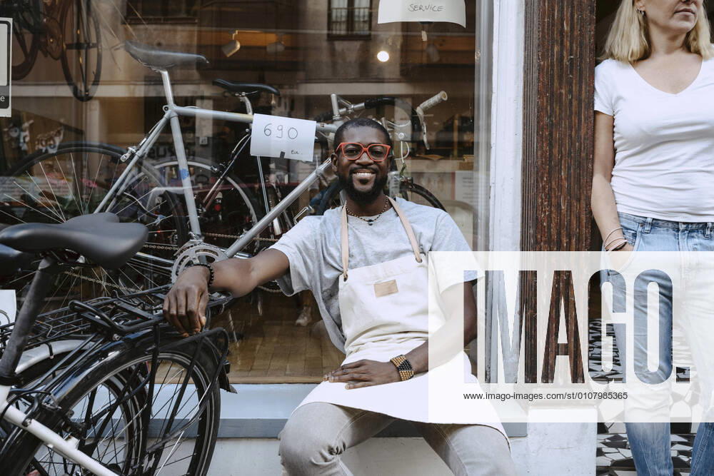 IMAGO Creative: Kreative Renaissance -- der junge Entrepreneur Portrait of confident owner sitting against bicycle shop, MA82932, Germany, Berlin, model released, property released