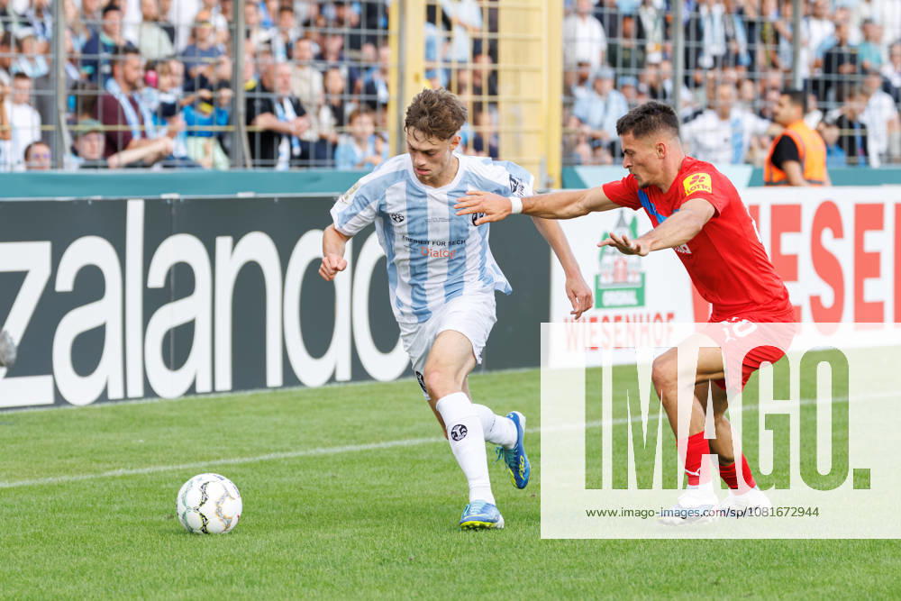 Emre Erdogan (19, TSV 1860 München) und Adrian Kapralik (20, Holstein Kiel) beim Spiel zwischen TSV 1860 München v Holstein Kiel, Fussball, Herren, Dfb Pokal, 2026 2027, 1.Runde am 22.08.2026 in München, Städtisches Stadion an der Grünwalder Straße. Bayern Deutschland