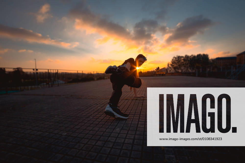 Teenager break dancing in evening park, Model released