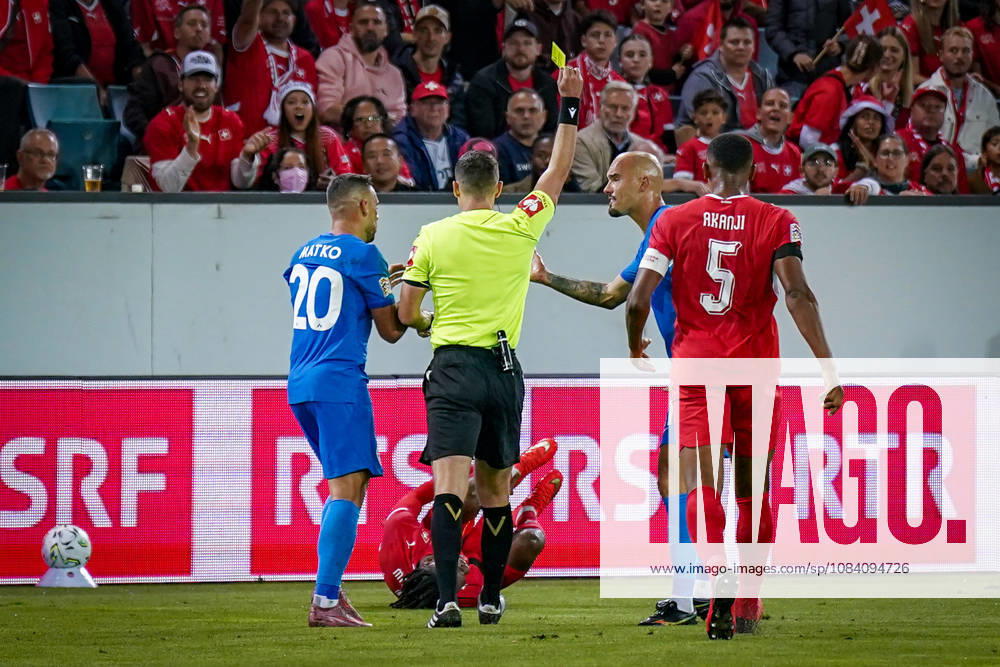 Fussball UEFA Nations League 2026 - 2027, 3. Spieltag - Schweiz vs Slowenien - Thermoplan Arena (Luzern): Schiedsrichter Ivan Kruzliak (Slowakei) zeigt Vanja Drkusic (Slowenien, 21) Gelbe Karte nach Foul an Johan Manzambi (Schweiz, 9)