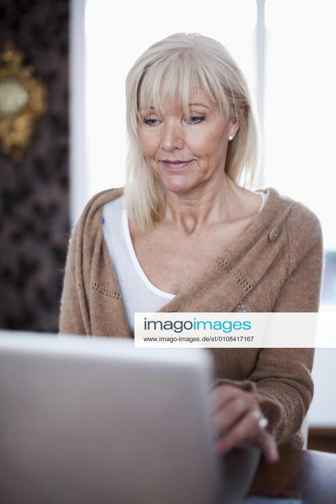 Senior woman using laptop at home , model released