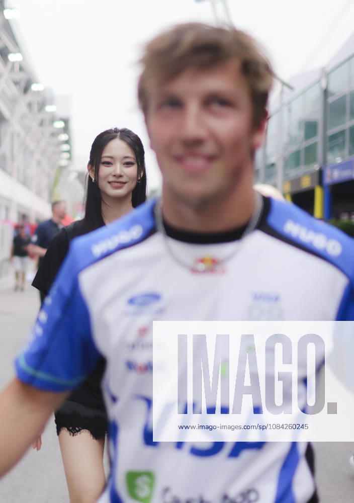 LIAM LAWSON of Oracle Red Bull Racing playfully takes the hand of TZUYU (CHOU TZU-YU), Taiwanese member of K-pop girl group TWICE, before walking away, making her burst into laughter during her visit to the Williams Racing paddock ahead of the 2026 Formula 1 Singapore Grand Prix at Marina Bay Street Circuit Singapore Singapore - ZUMAh201 20261008_zsp_h201_030