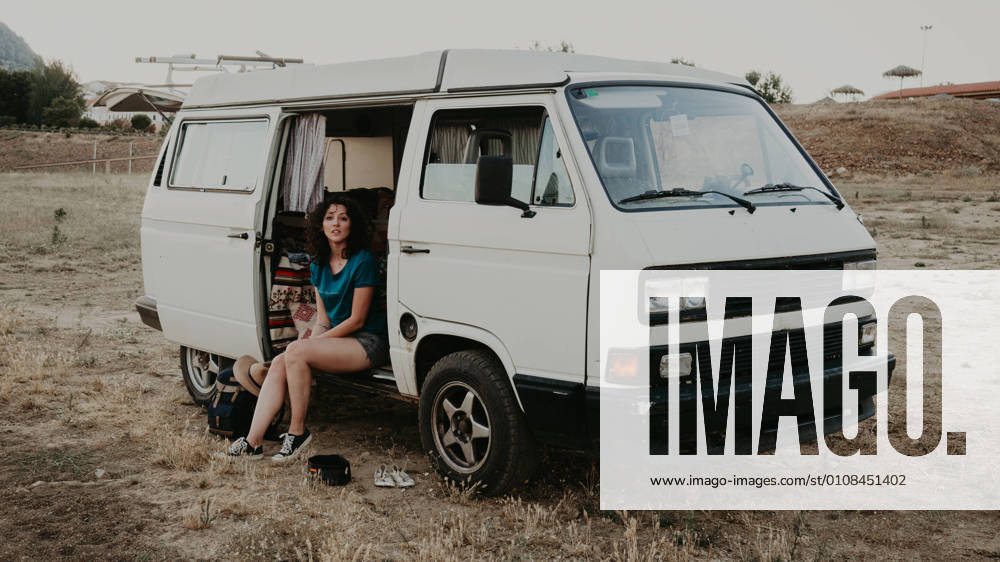 IMAGO Creative: Ende des Sommers Attractive young woman sitting in a cool looking at camera in the middle of nowhere in summer