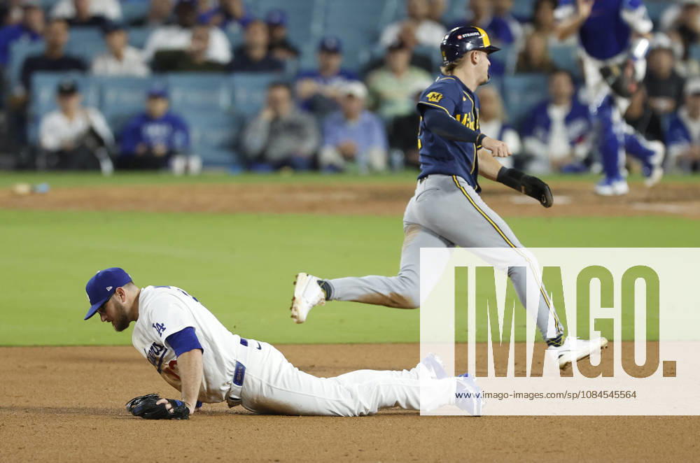 Los Angeles Dodgers third baseman Max Muncy (13) dives for a sharp grounder by Milwaukee Brewers Joey Ortiz as Brewers Cooper Pratt races past to score in the ninth inning in the MLB, Baseball Herren, USA National League Championship Series playoffs at Dodger Stadium in Los Angeles, California, on Wednesday, October 14, 2026. LAP20261014743 CAROLINExBREHMAN