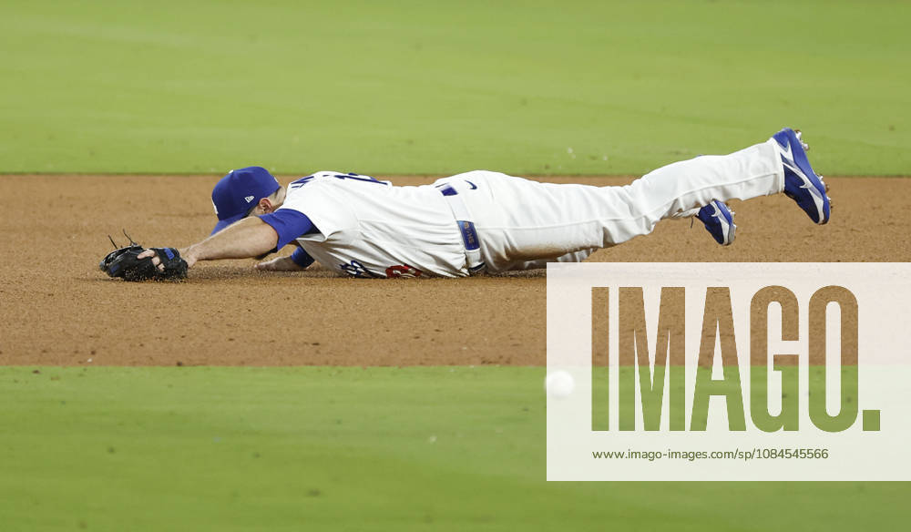 Los Angeles Dodgers third baseman Max Muncy (13) dives for a sharp grounder by Milwaukee Brewers Joey Ortiz in the ninth inning in the MLB, Baseball Herren, USA National League Championship Series playoffs at Dodger Stadium in Los Angeles, California, on Wednesday, October 14, 2026. LAP20261014744 CAROLINExBREHMAN