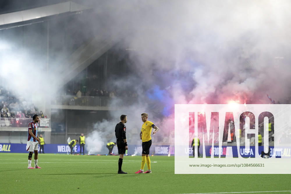 LKS 20261015 KuPS captain Petteri Pennanen (R) talks with referee Ishmael Barbara as fans light flares in the stands during the football UEFA Conference League League Phase match between KuPS Kuopio and Trabzonspor in Tampere, Finland, on October 15, 2026. - MIKA KYLMÄNIEMI Tampere Finland 5Ec8e_6GBT8