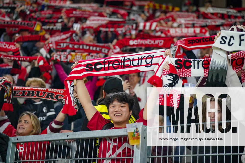 Deutschland: Fussball UEFA Conference League 2026 - 2027, 1. Spieltag - SC Freiburg vs FK Jablonec - Europa-Park-Stadion (Freiburg): Lächelnder Fan des SC Freiburg hält einen rot-weissen Fanschal mit der Aufschrift scfreiburg über den Kopf. Porträt eines begeisterten Anhängers auf der Tribüne des Europa-Park-Stadions beim UEFA Conference League-Spiel gegen FK Jablonec. SC Freiburg, FK Jablonec, Fussball, Europapokal, Fussballfan, Fans, Zuschauer, Fankultur, Fanschal, Vereinsfarben, Vereinswappen, Fanartikel, Merchandising, Emotionen, Begeisterung, Heimfans, Stadion, Tribüne, Supporter, Fanblock.
