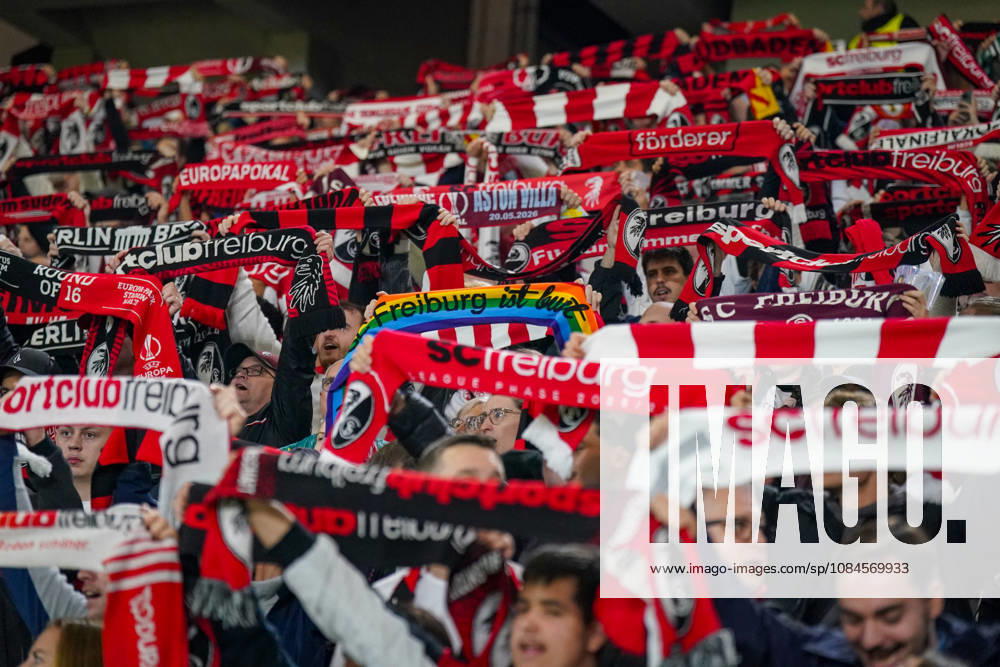 Deutschland: Fussball UEFA Conference League 2026 - 2027, 1. Spieltag - SC Freiburg vs FK Jablonec - Europa-Park-Stadion (Freiburg): Fans des SC Freiburg halten auf der Tribüne des Europa-Park-Stadions zahlreiche rot-weisse und schwarz-rote Fanschals in die Höhe. Geschlossenes Fanbild beim UEFA Conference League-Spiel gegen FK Jablonec. Sichtbar ist auch ein Regenbogenschal mit der Aufschrift Freiburg ist bunt. SC Freiburg, FK Jablonec, Fussball, Europapokal, Fans, Zuschauer, Fankultur, Fanblock, Fanschals, Vereinsfarben, Solidarität, Vielfalt, Diversität, Toleranz, LGBTQ, Stimmung, Heimfans, Supporter, Fanartikel, Stadion.
