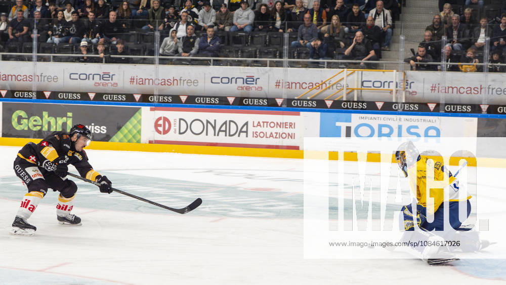 Alessio Bertaggia of Lugano L) against goalkeeper Sandro Aeschlimann of Davos R) during the game between HC Lugano v HC Davos at the Corner Arena on October 16, 2026 in Lugano, Switzerland. Lugano Ticino Switzerland