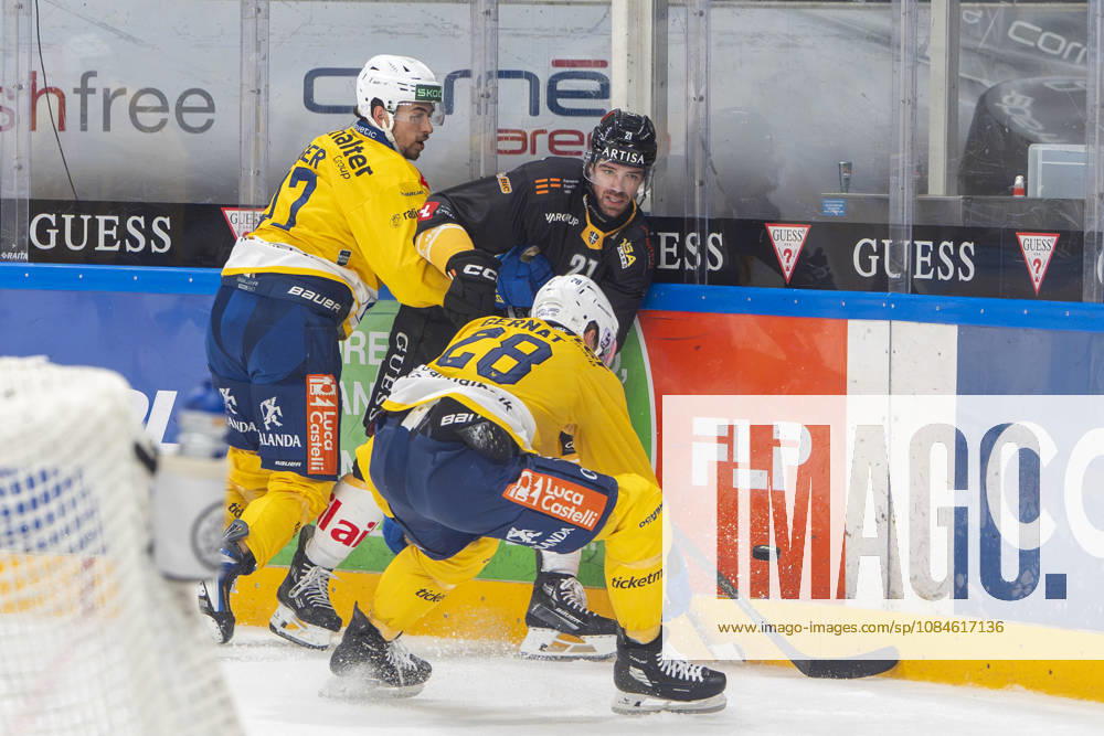 Zach Sanford of Lugano C) against Ken Jager of Davos L) and Martin Gernat of Davos R) during the game between HC Lugano v HC Davos at the Corner Arena on October 16, 2026 in Lugano, Switzerland. Lugano Ticino Switzerland
