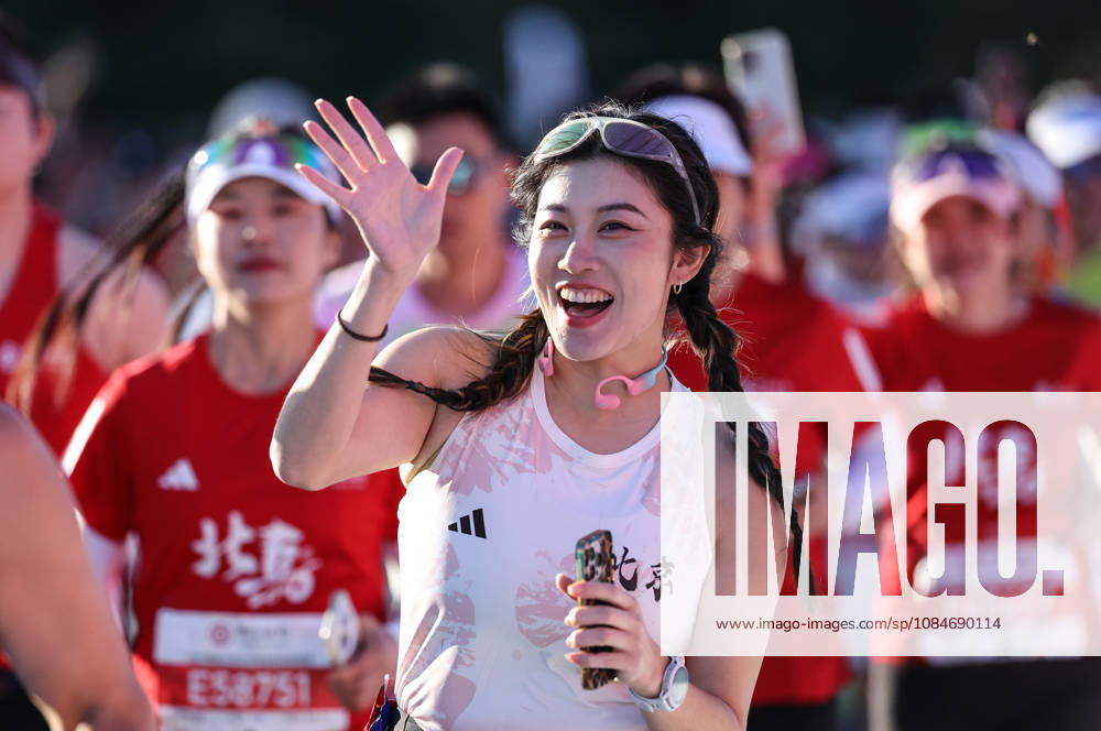 (261018) -- BEIJING, Oct. 18, 2026 -- A runner waves to cameras as she competes during the 2026 Beijing Marathon & National Marathon Championships in Beijing, capital of China, Oct. 18, 2026. ) (SP)CHINA-BEIJING-2026 BEIJING MARATHON(CN) LixMing