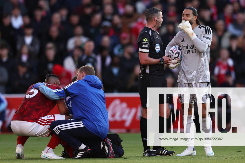 Nottingham, England, 18th October 2026. Murillo of Nottingham Forest receives medical treatment while David Raya of Arsenal talks with referee Michael Oliver during the Nottingham Forest vs Arsenal Premier League match at the City Ground, Nottingham. Picture credit should read: Jake Youle Sportimage . SPI_025_JY_Forest_Arsenal SPI-5083-0025