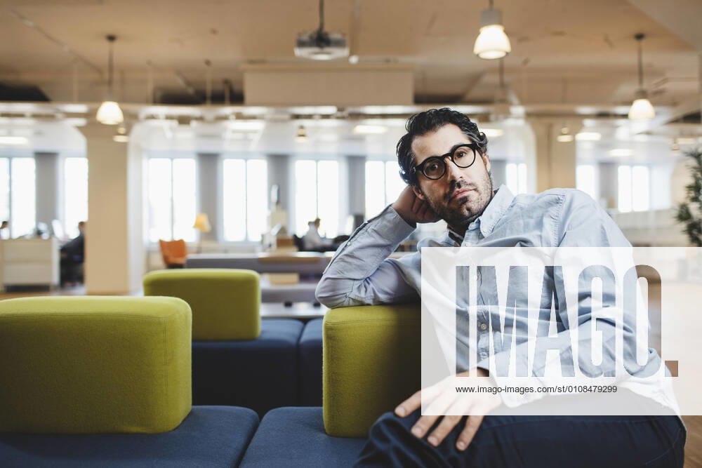 Portrait of mature man sitting on couch at corridor , model released