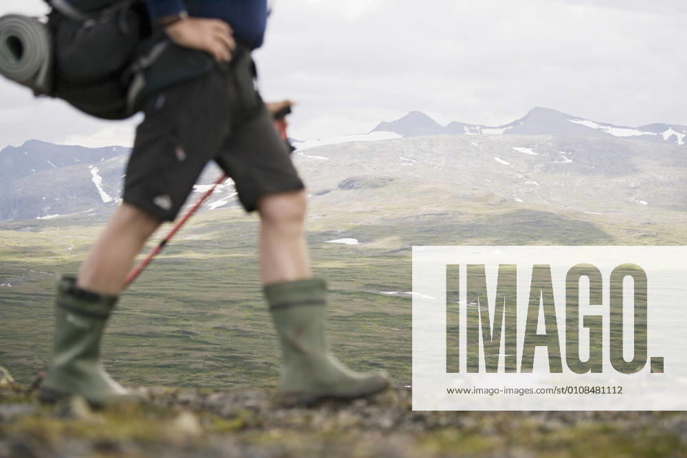 Low section of hiker walking against mountains , model released