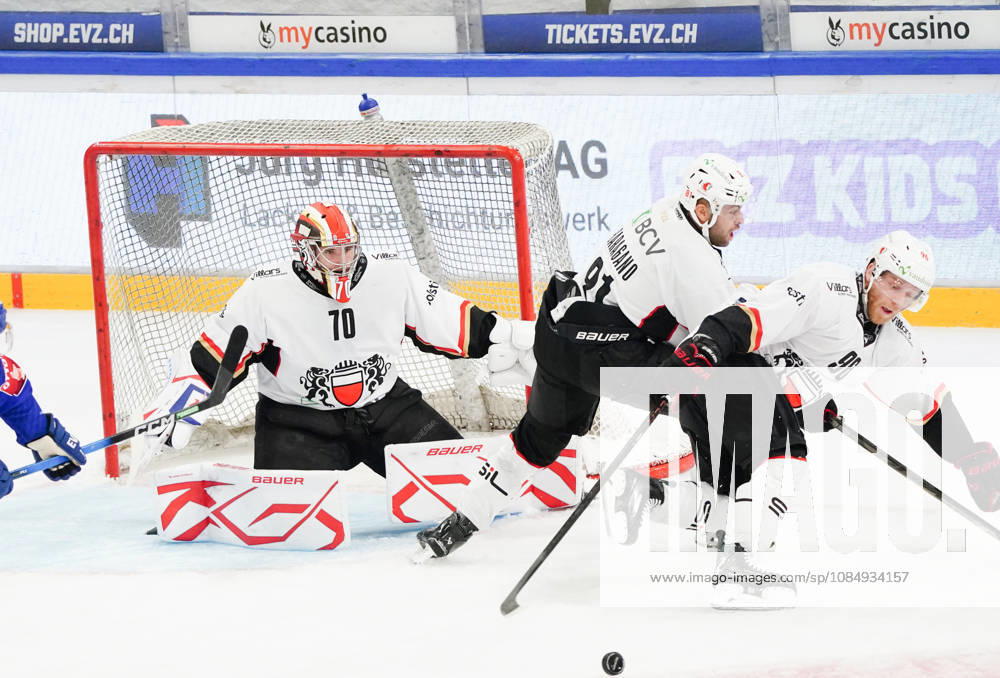Zug Schweiz. Eishockey Herren Saison 2026-2027 EV Zug - HC Lausanne. Bild. Torhueter Ewan Huet,91 Fabian Heldner,96 Drake Caggiula alle Lausanne HC Aktion