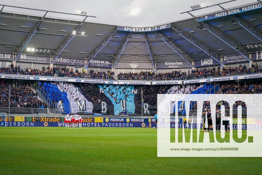 Deutschland: Fussball Bundesliga 2026 - 2027, 7. Spieltag - SC Paderborn vs Hamburger SV - Home-Deluxe-Arena (Paderborn): Totale der Home-Deluxe-Arena in Paderborn, Innenansicht mit grosser blau-schwarz-weisser Choreographie der Heimfans des SC Paderborn 07 auf der Tribüne, Schriftzug HAMBURG. Fanchoreo, Ultras, Fanszene, Zuschauer, Fahnen, Fanblock, Stimmung, Mannschaftskreise beider Teams vor Spielbeginn, Hamburger SV, HSV, SC Paderborn, Fussball, Bundesliga, Sportstätte, Stadiondach, Flutlicht, Spielfeld, Sponsoren, Werbung, Werbebanden, Merkur, buXtrade, Varnholt, Welcome Hotel.