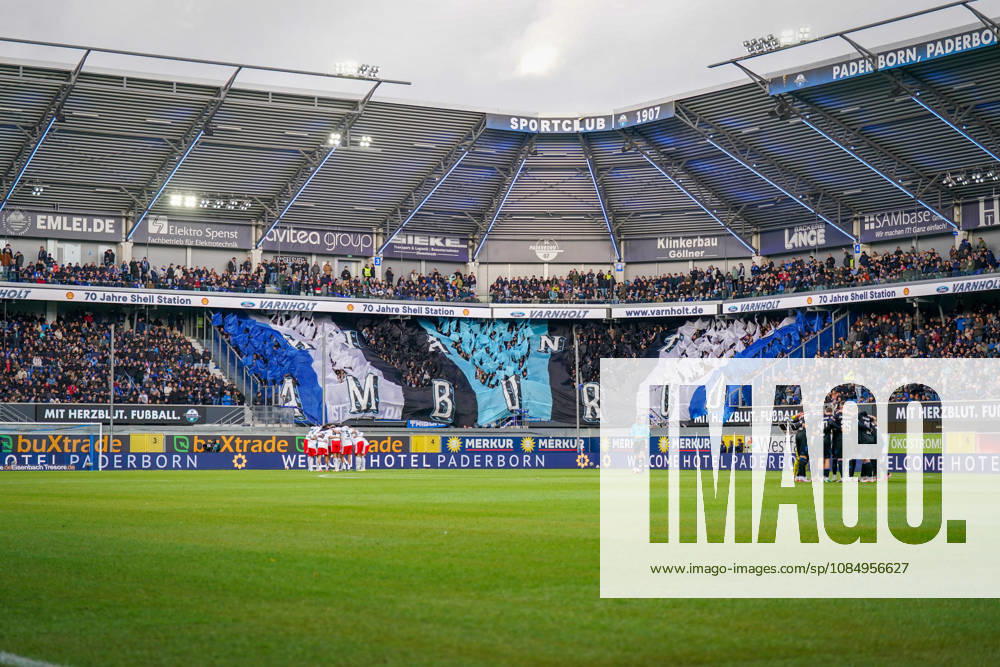 Deutschland: Fussball Bundesliga 2026 - 2027, 7. Spieltag - SC Paderborn vs Hamburger SV - Home-Deluxe-Arena (Paderborn): Innenansicht der Home-Deluxe-Arena in Paderborn mit grosser blau-schwarz-weisser Choreographie der Heimfans des SC Paderborn 07, Schriftzug HAMBURG. Fans, Ultras, Fanchoreo, Fanszene, Fahnen, Zuschauer, Tribüne, Fanblock, Stimmung, Mannschaftskreise von SC Paderborn und Hamburger SV vor Spielbeginn, Fussball, Bundesliga, Stadion, Sportstätte, Totale, Spielfeld, Schiedsrichter, Flutlicht, Werbung, Sponsoren, Werbebanden, Merkur, buXtrade, Varnholt, Welcome Hotel.