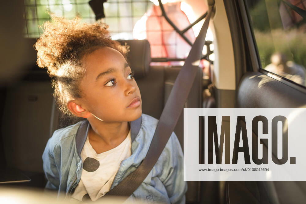 IMAGO Creative: Klimawandel - Zukunft und Innovation Girl looking through window while sitting in electric car , model released