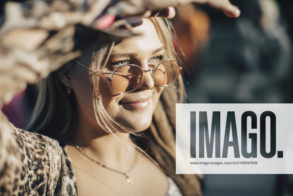 Close-up of smiling woman sheilding eyes while looking away in summer , model released