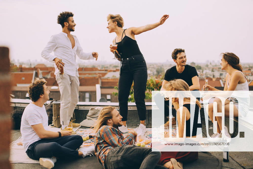 IMAGO Creative, Urban Lifestyle IMAGO Kreativ: Urbane Kultur - Sommer auf den Dächern Happy people dancing while enjoying music with friends on terrace at rooftop party , model released, property released