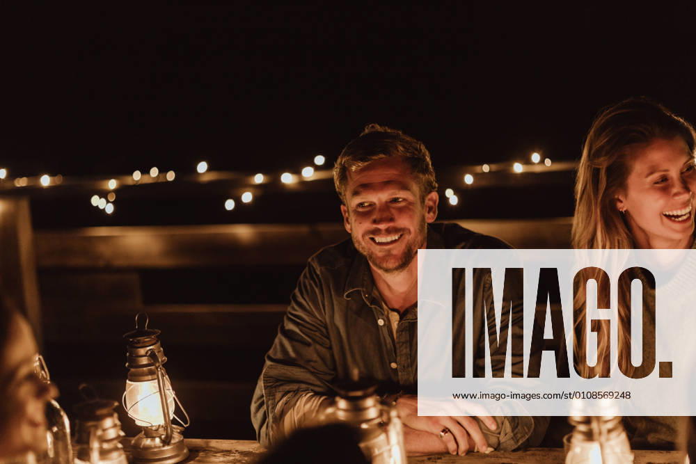 IMAGO Creative, Jahreszeit Sommer, Sommer in der Stadt IMAGO Creative: Landleben - Essen IMAGO Creative: Landleben - Alfresco, Draußen Smiling man sitting with female friend in restaurant at night , model released, property released