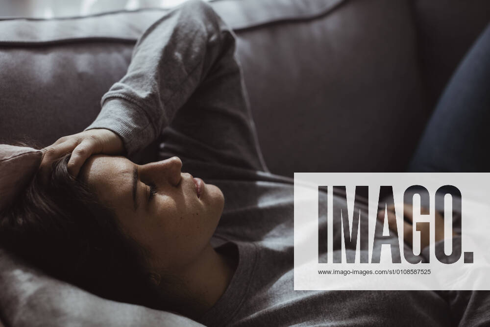 Close-up of stressed woman lying on sofa at home Sweden, Stockholm, model released, property released