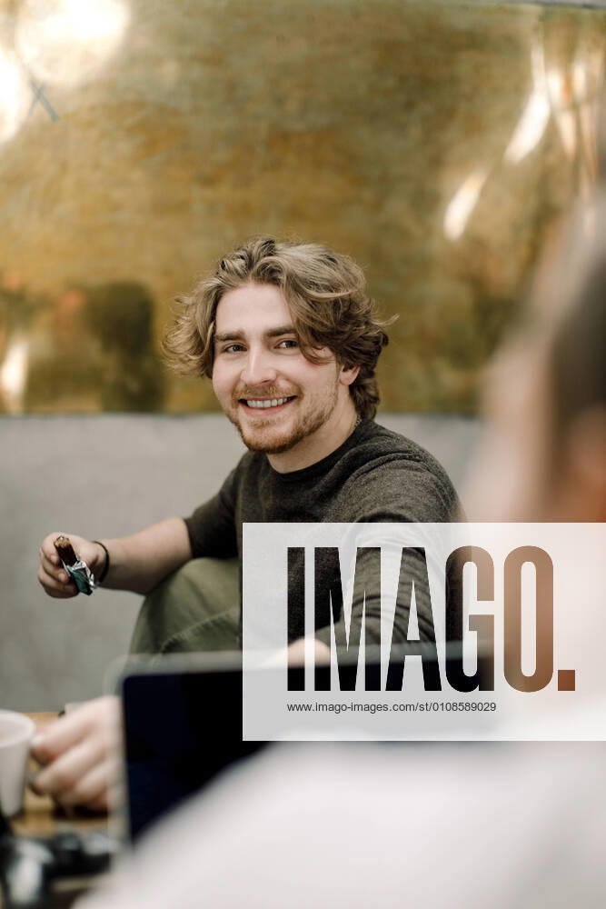 Portrait of smiling business person sitting in office Sweden, Stockholm, model released, property released