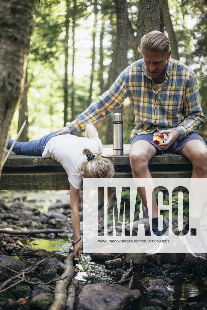 IMAGO Creative: Gesundheit, Burnout IMAGO Creative: Landleben - Essen IMAGO Creative: Klimawandel - Umwelterziehung IMAGO Creative: Klimawandel - Grüne Erholung Father with apple holding daughter fishing on footbridge in forest Sweden, Stockholm, model released