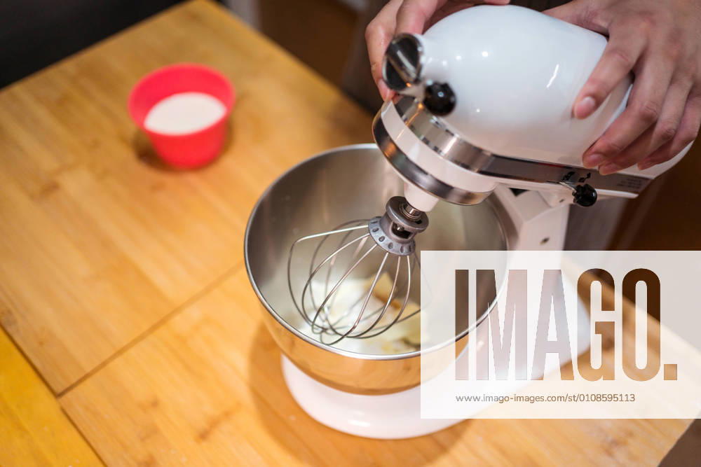 IMAGO Creative: Haushaltsger?te - K?chenmaschine From above faceless person installing wire whisk on stand mixer while preparing pastry at counter in kitchen