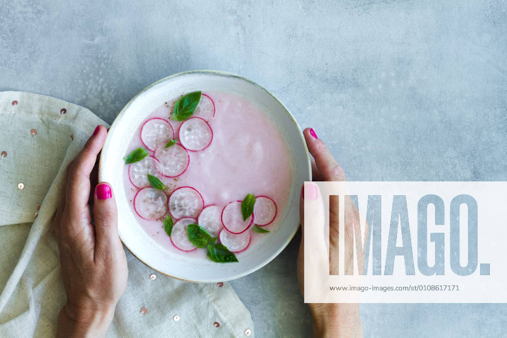IMAGO Creative, Sommer, Food, Radieschen Top view of crop anonymous female eating delicious refreshing radish cream soup with fresh basil leaves
