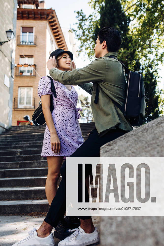 Young cheerful couple in casual clothes having fun during dating outdoors, Model released