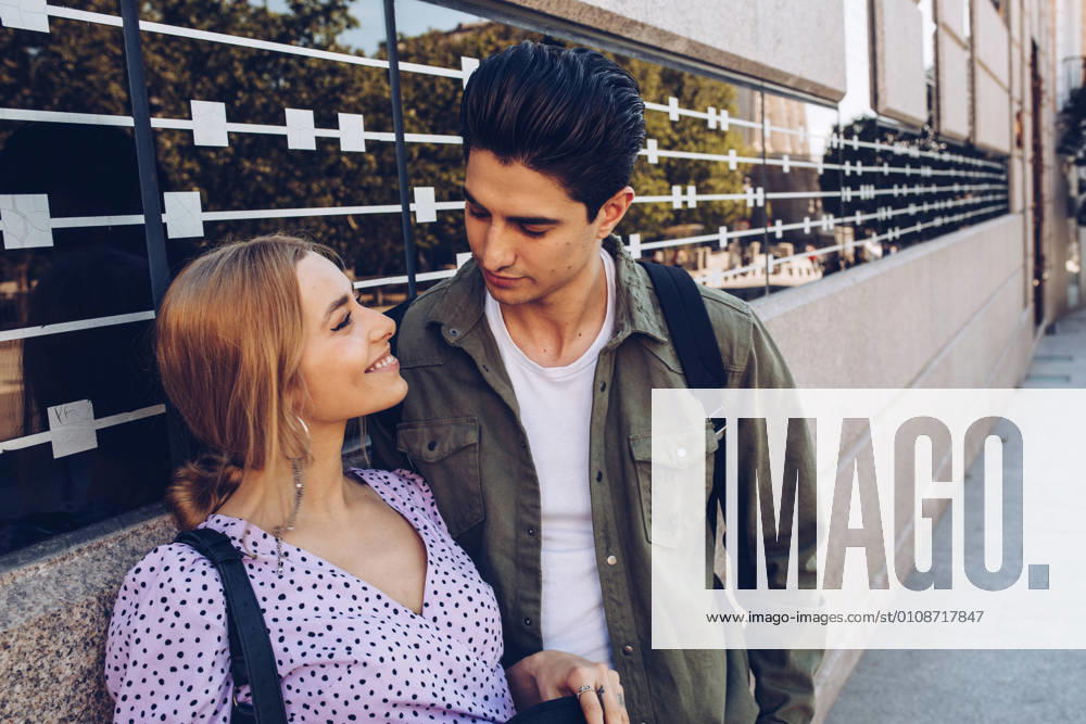 Young cheerful couple in casual clothes having fun during dating outdoors, Model released