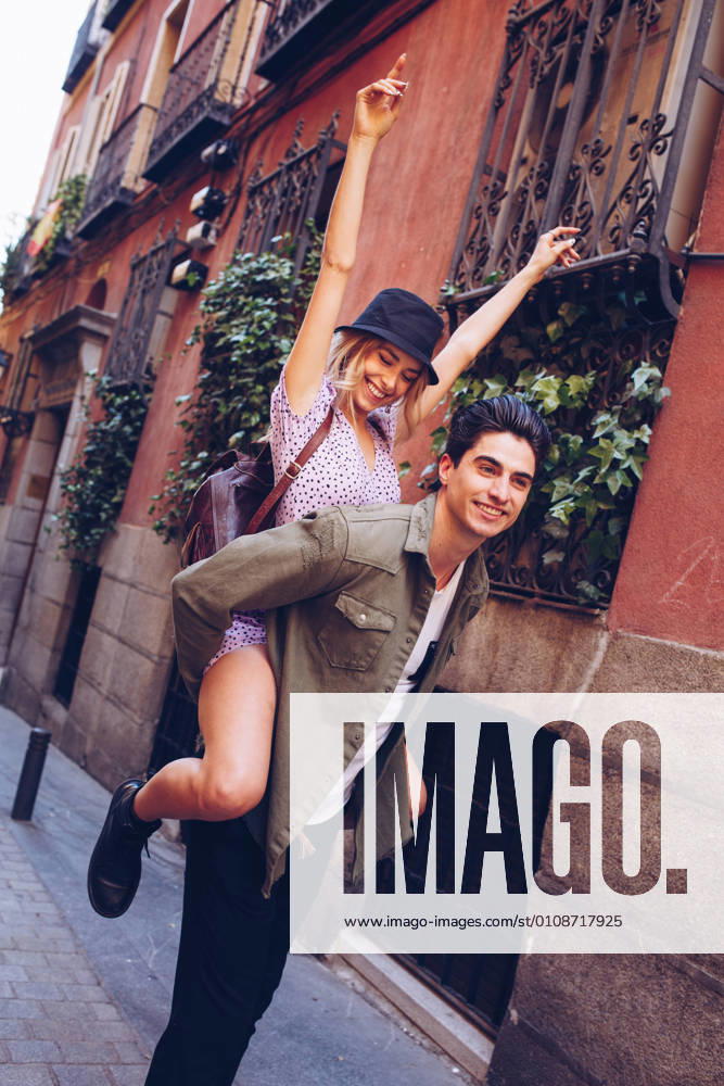 Young cheerful couple in casual clothes having fun during dating outdoors, Model released