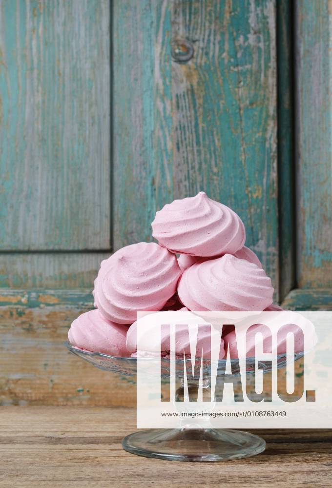 Pink meringues on wooden background. Party dessert BEW1D88CDC8