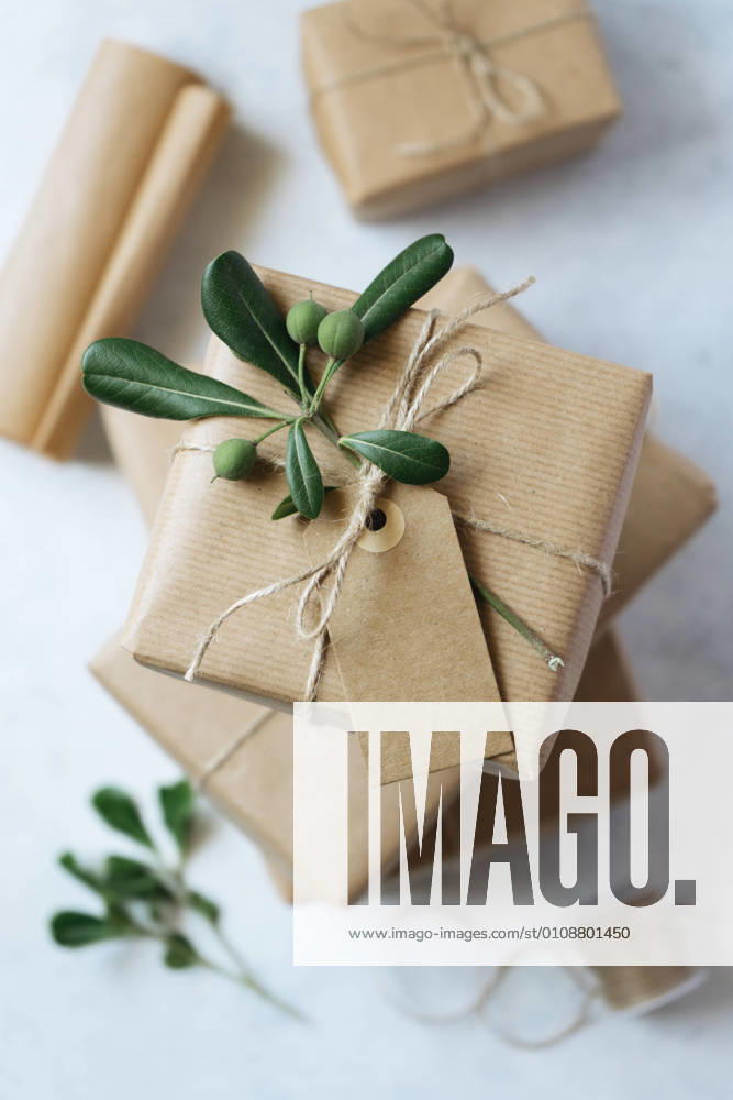 IMAGO Creative: Weihnachten, DIY, Geschenke verpacken - Nachhaltigkeit homemade wrapped presents on a white table