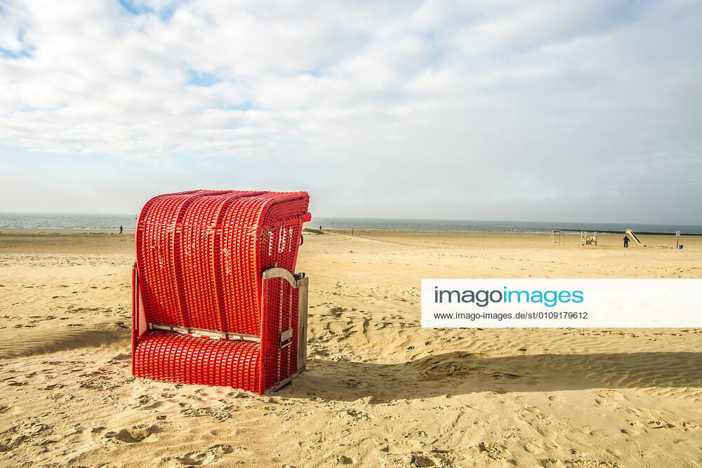 Ein roter Strandkorb steht am Strand von Borkum, Niedersachsen, Deutschland Herbst auf Borkum