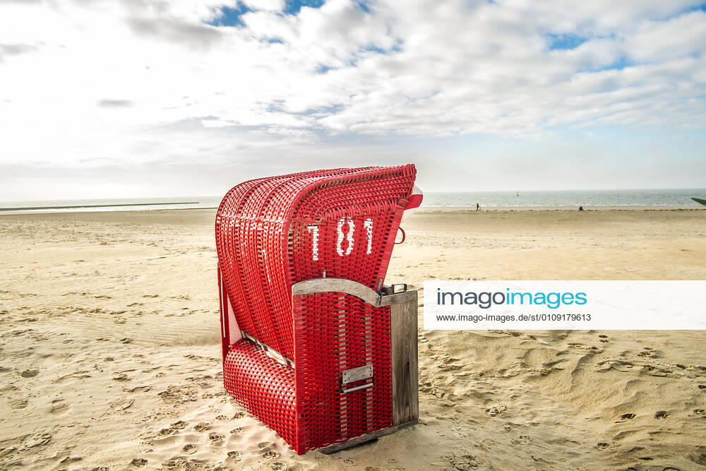 Ein roter Strandkorb steht am Strand von Borkum, Niedersachsen, Deutschland Herbst auf Borkum
