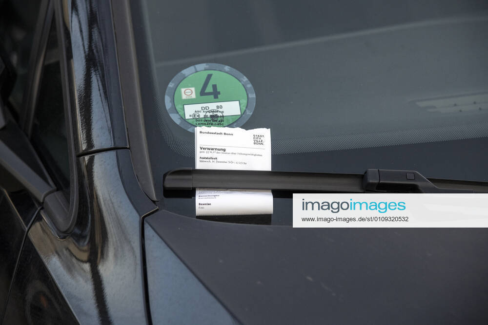 Ordnungswidrigkeit im ruhenden Verkehr. Strafzettel beziehungsweise Ticket oder Knöllchen hinter dem Scheibenwischer eines ordnungswidrig abgestellten Fahrzeugs. Sensible Daten sind elektronisch unkenntlich gemacht oder beseitigt. Bonn Nordrhein-Westfalen Deutschland