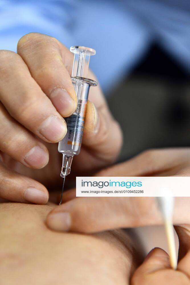 (210105) -- BEIJING, Jan. 5, 2021 -- A medical worker inoculates a recipient with a COVID-19 vaccine at a hospital in Jinan of east China s Shandong Province, Jan. 4, 2021. A total of 217,158 doses of COVID-19 vaccines have been administered to key groups with higher risks of infection in east China s Shandong Province, authorities said on Monday. ) XINHUA PHOTOS OF THE DAY GuoxXulei