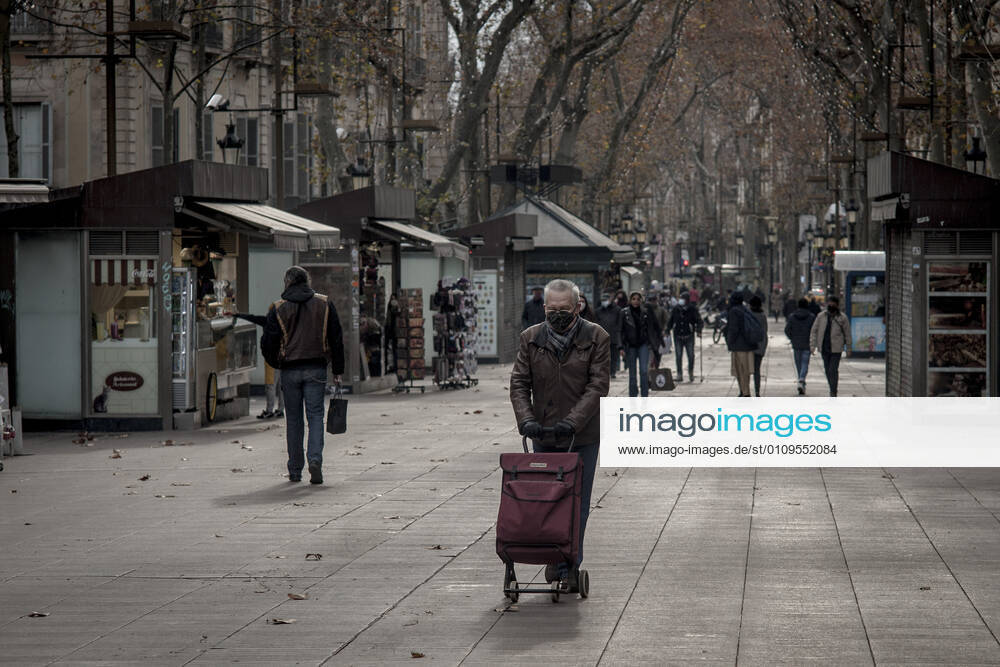 A man wearing a face mask pushes the shopping cart along La Rambla in Barcelona. At the end of the Christmas holiday season, several regions in Spain have tightened measures to stop the spread of the coronavirus third wave as hospitals pressure is rising. Some studies conclude that the new strain of coronavirus that was first detected in the United Kingdom has been circulating in Spain for two weeks. Barcelona Spain - ZUMAb137 20210107_zap_b137_004