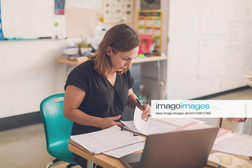 Elementary school teacher organizing papers in her classroom. San Diego, CA, United States CR_CHDO210108-535001-01 ,model released, Symbolfoto
