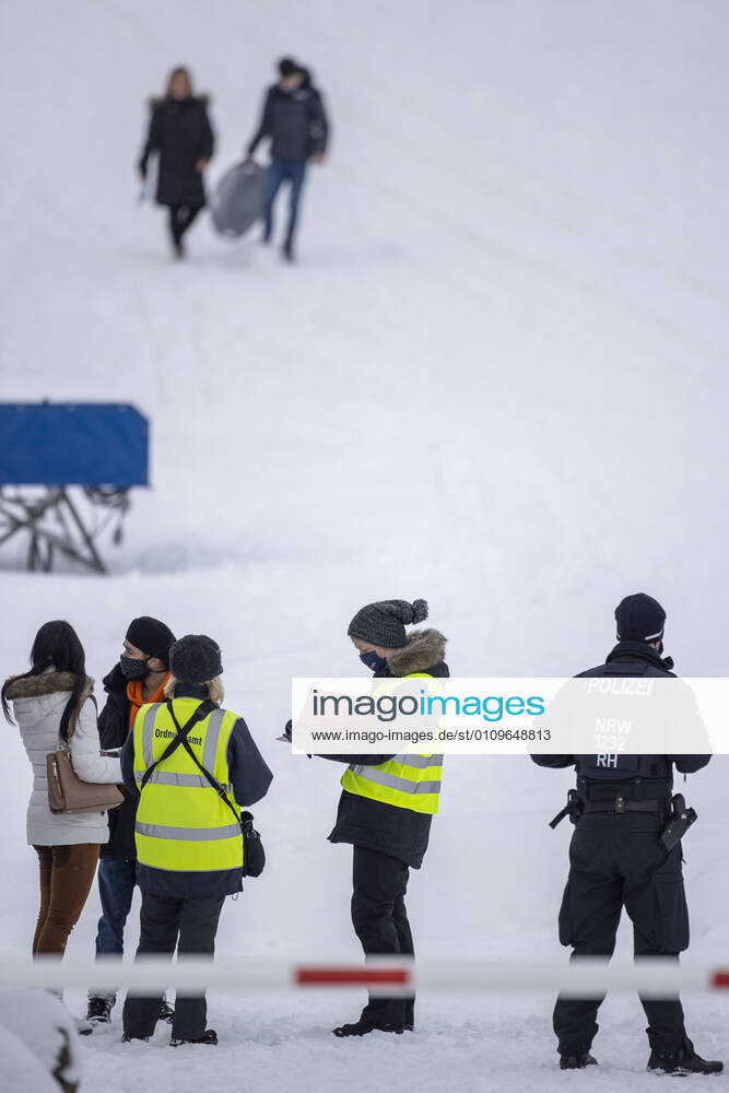 WINTERBERG , SAUERLAND , Winter , Schnee , Winterberg bereitet sich auf den nächsten Ansturm der Menschen am Wochenende vor. Sperrschilder an den Eingängen zu den Skigebieten. Am Samstag viel weniger Menschen im Ort als noch vor Wochenfrist. Einige wenige Menschen betreten die abgesperrten Skipisten trotz der Verbote , sie müssen mit Bussgeldern rechnen. Polizei und Ordnungsamt nehmen die Personalien auf.