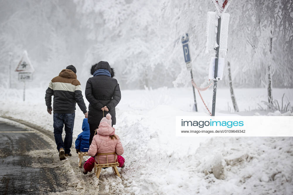 WINTERBERG , SAUERLAND , Winter , Schnee , Winterberg bereitet sich auf den nächsten Ansturm der Menschen am Wochenende vor. Ein Touristenpaar aus Köln zieht die beiden Kinder auf Schlitten durch den Schnee.