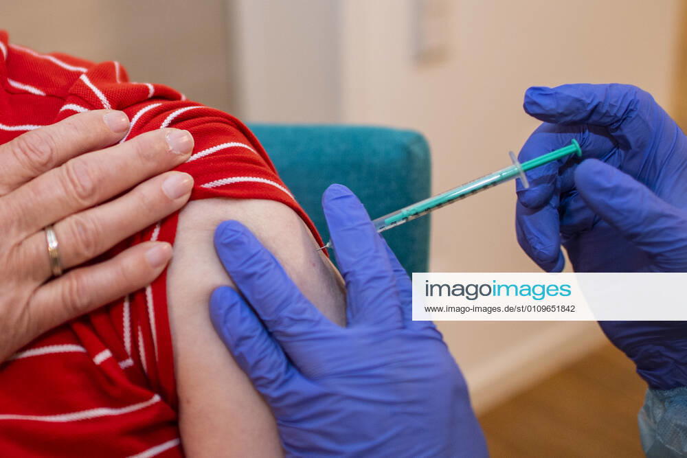 Corona-Schutzimpfung in einem Seniorenheim Ein Arzt setzt die Nadel am Oberarm eines Bewohners eines Altenheims an, der gegen eine Infektion mit dem Coronavirus geimpft wird. In einem Seniorenheim werden die Bewohner gegen eine Infektion mit dem Coronavirus geimpft. Für den Aufbau des Impfschutzes sind mit dem mRNA-Impfstoff von BioNTech zwei Impfungen im Abstand von 21 Tagen notwendig. Rietberg Nordrhein-Westfalen Deutschland